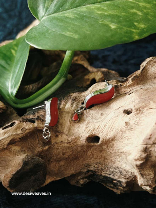 Red and silver earrings on a piece of wood
