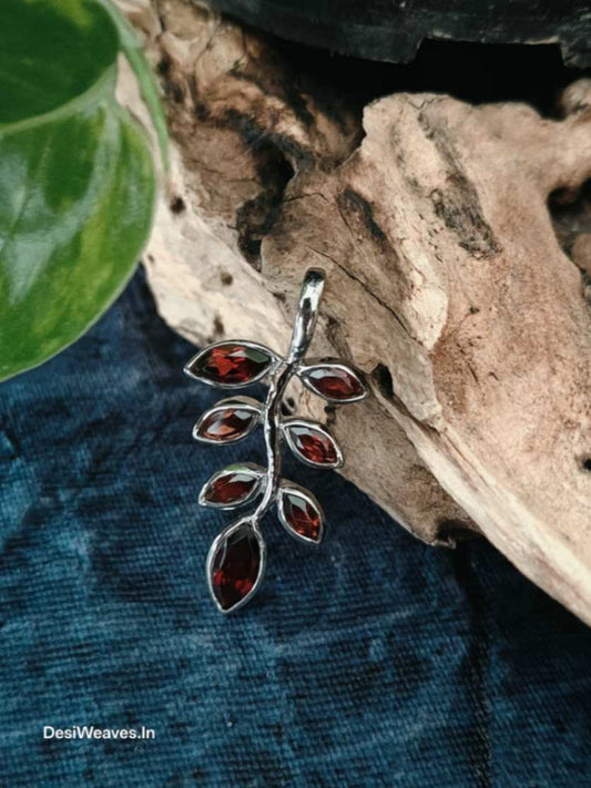 Silver pendant with red stones on a natural background