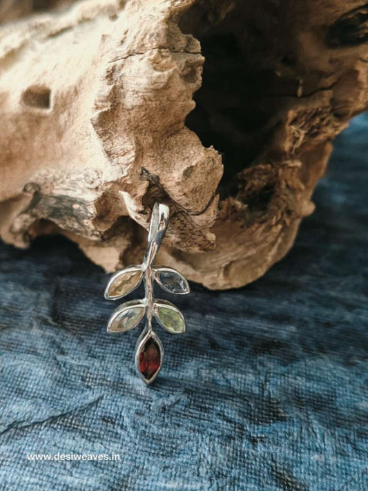Silver pendant with leaves and a red stone